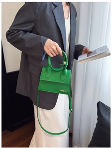 Vue détaillée du sac à main trapèze vert vif avec logo en métal et poignée ronde
