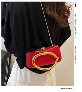 Pochette de soirée rouge avec poignée dorée et bandoulière portée par un mannequin