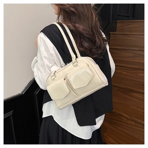 Detailansicht der cremefarbenen Retro-Achseltasche mit zwei Frontklappentaschen an der Schulter