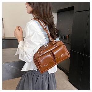 Braune Vintage-Achseltasche mit zwei Taschen und glänzendem Leder-Finish am Model