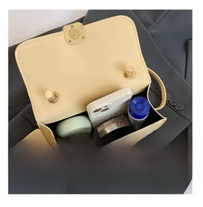 Detail presentation showing internal capacity of the beige square crossbody bag