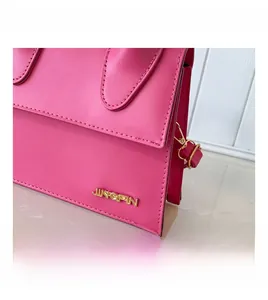 Gros plan du sac à main rose en cuir PU avec logo JINGPIN et détails en métal doré