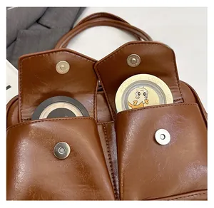 Nahaufnahme der beiden Fronttaschen einer braunen PU-Ledertasche für Kosmetikartikel