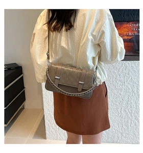Detail of vintage taupe crossbody bag with checkered embossing and braided handle