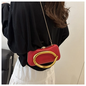 Vue détaillée du sac de soirée en cuir rouge avec boucle ovale dorée et bandoulière
