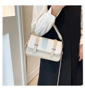 Detail of cream white faux leather bag with crocodile texture and woven handle
