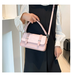 Detail of pink patchwork crossbody bag with woven handle and plaid embossed flap
