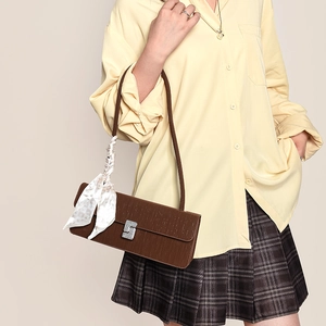 Brown faux leather baguette bag with vertical texture and silk scarf accessory