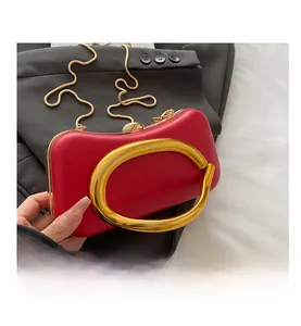 Détail d'une pochette de soirée rouge avec poignée ronde dorée et bandoulière