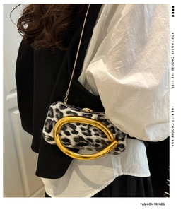 Detail of leopard print evening bag with chunky gold metal handle and chain strap