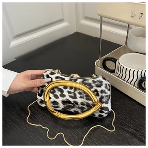 Detail of leopard print evening bag featuring a round gold handle and metal chain strap