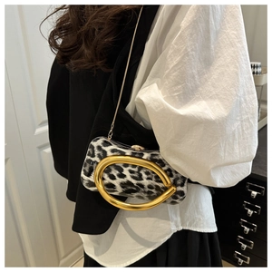 Detailed close-up of leopard print evening bag with metallic gold handle and chain strap