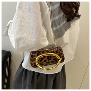 Detail of leopard print handbag with large golden C-handle and metallic chain strap
