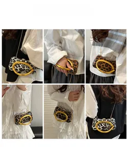 Detail view of leopard print clutch with large gold ring handles and chain strap