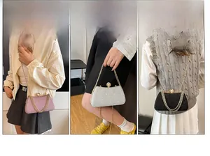 Detail of luxury box clutch bags in pink, silver and black with pearl lock and gold chain