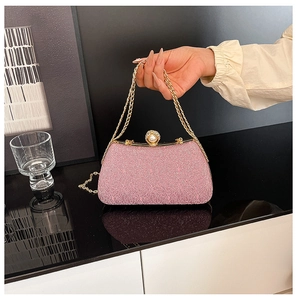 Detailed view of pink shimmer box bag featuring pearl clasp and gold chain strap