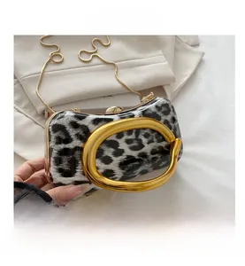 Detailed close-up of leopard print evening bag with golden circular handle and chain