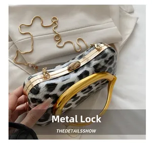 Macro shot of the luxury gold metal clasp on a leopard print evening clutch bag