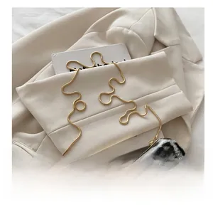 Detail of leopard print evening bag with golden handle and sleek snake chain strap