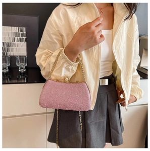 Detail of pink embroidered box bag featuring luxury pearl and rhinestone lock with gold chain