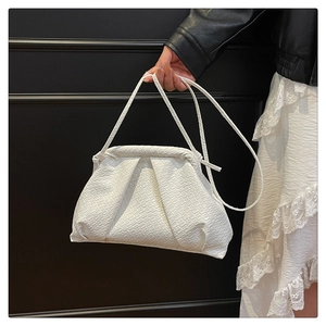 Detail of white woven cloud pouch bag with natural folds and slim leather shoulder strap