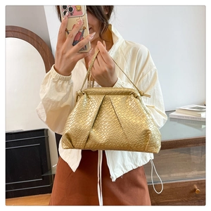 Detail of gold woven cloud bag showing metallic leather texture and elegant pleated style