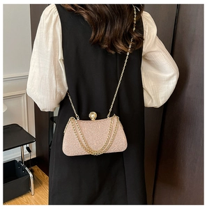 Detail of champagne pink glitter evening clutch bag with pearl clasp and gold chain strap