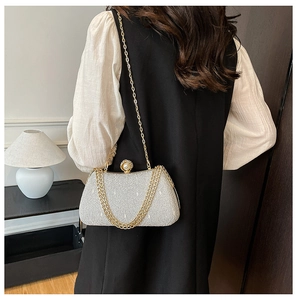 Detail of silver sequin evening clutch bag with pearl clasp and golden chain strap