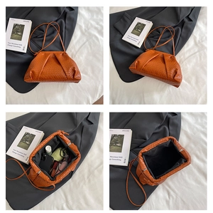 Macro view of burnt orange woven cloud bag texture and interior compartment details