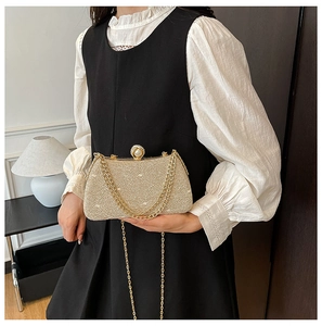 Detail of champagne gold sequin clutch bag featuring a pearl clasp and fine chain