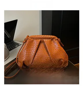 Detail shot of caramel cloud bag showing woven texture and matching shoulder strap