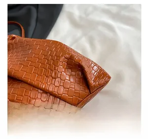 Macro shot of caramel brown woven leather texture and detailed interlaced pattern on bag