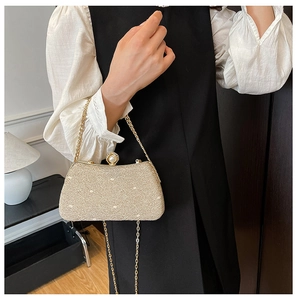 Close-up of golden sequin clutch with pearl clasp and metallic chain strap detail