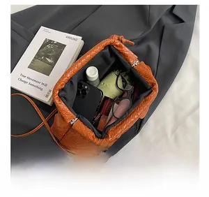 Top view of brown woven shell bag interior showing storage for phone and sunglasses