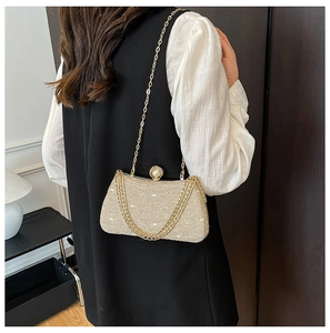 Detail of champagne gold sequin box bag with pearl clasp and golden chain strap