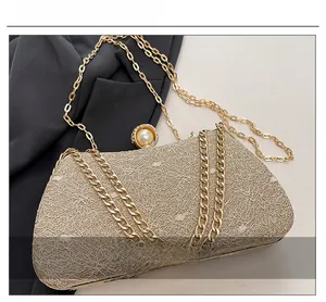 Detail of champagne wire mesh texture and large pearl clasp on the box clutch bag