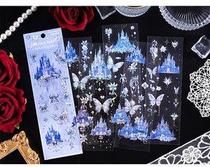 Macro detail of laser silver stickers featuring blue castles and butterflies on black lace