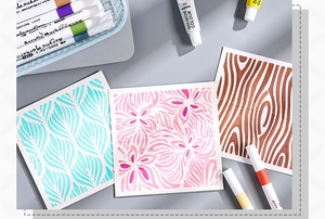 Detailed view of floral PET stencil artwork with acrylic markers on a grey surface
