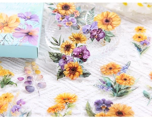 Detailed close-up of vibrant sunflower and floral stickers on white textured fabric