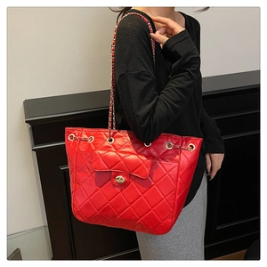 Détail du grand sac cabas rouge matelassé avec bandoulière chaîne et poche avant