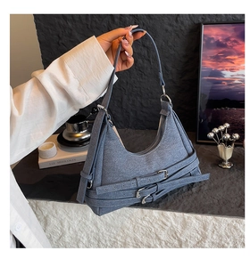 Détail du sac hobo en jean bleu avec boucles argentées et style streetwear vintage