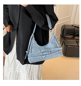 Détail du sac sous le bras en denim bleu clair avec boucles métalliques et garnitures argentées