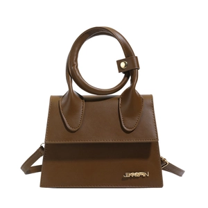 Sac trapèze en cuir mat marron foncé avec poignée circulaire et finitions dorées