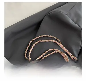 Détail de la bandoulière en cuir rose et chaîne dorée sur un sac cabas chic