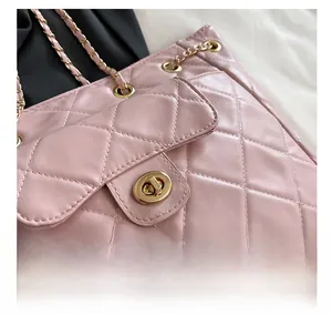 Vue macro du cuir matelassé rose avec fermoir doré sur le sac à bandoulière chaîne