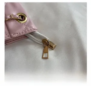 Détails de la fermeture éclair dorée et du cuir matelassé rose du sac cabas
