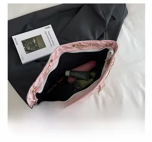 Intérieur spacieux d'un grand sac cabas rose matelassé avec divers objets personnels