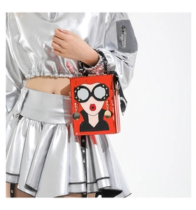 Détail du sac à main boîte rouge avec motif visage de fille et foulard au manche