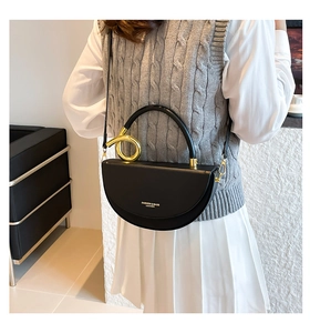 Détail du sac à main demi-lune en cuir avec poignée à anneau métallique doré chic