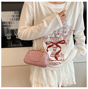 Close-up of pink sequined evening bag with sparkling rhinestone clasp and gold chain strap